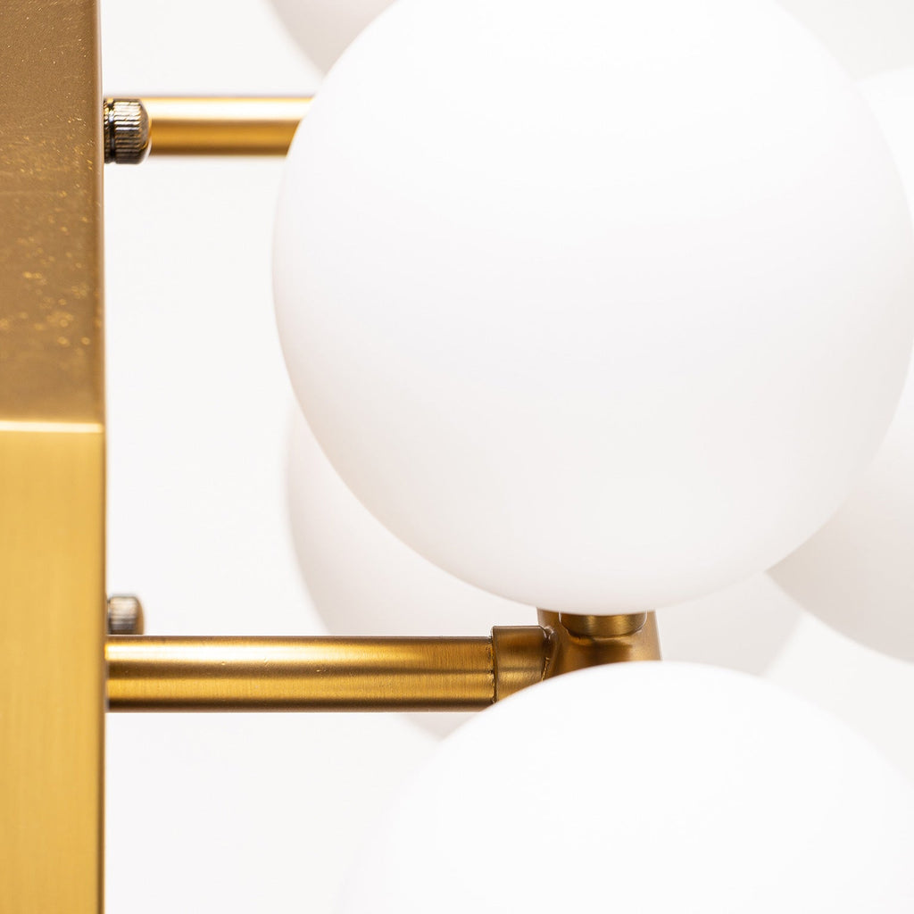 Goldene Wandleuchte kombiniert mit mattweissen Glaskugeln - Maison Oudh