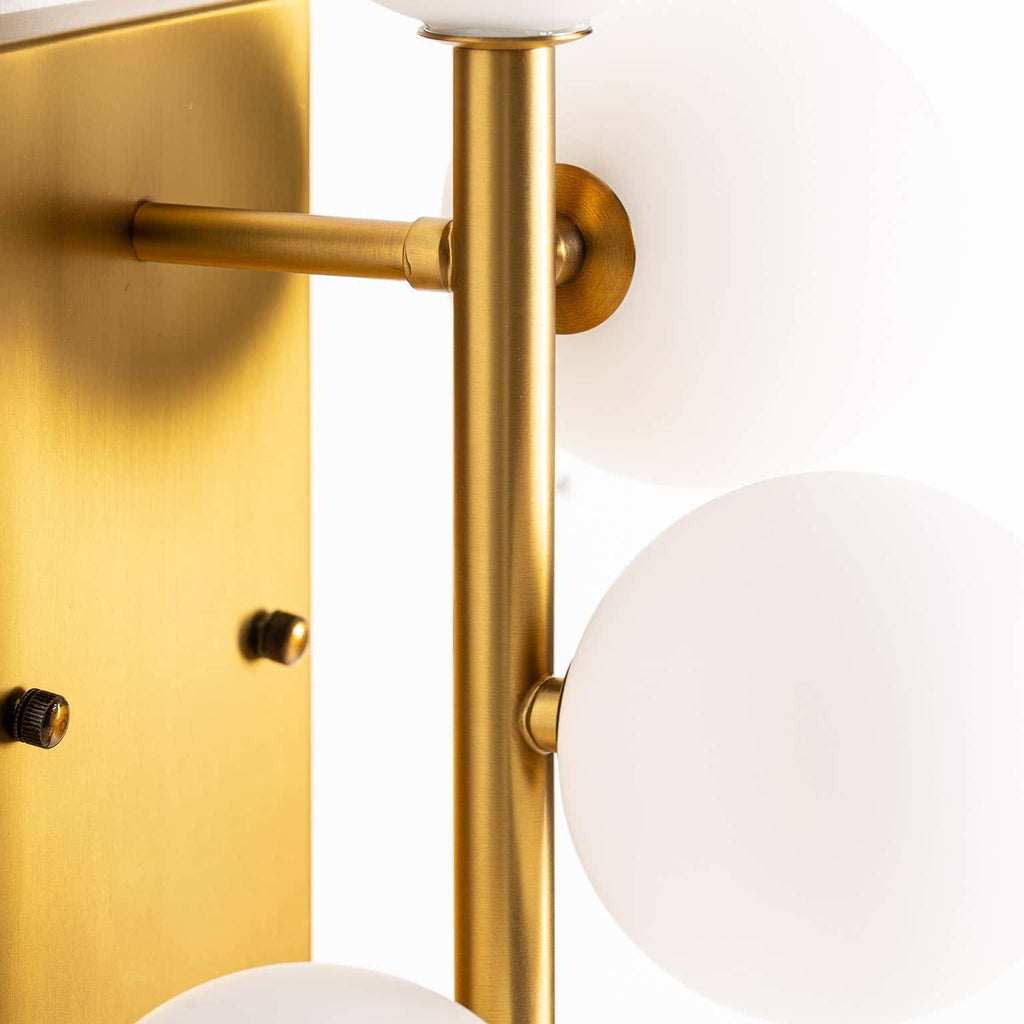 Goldene Wandleuchte kombiniert mit mattweissen Glaskugeln - Maison Oudh